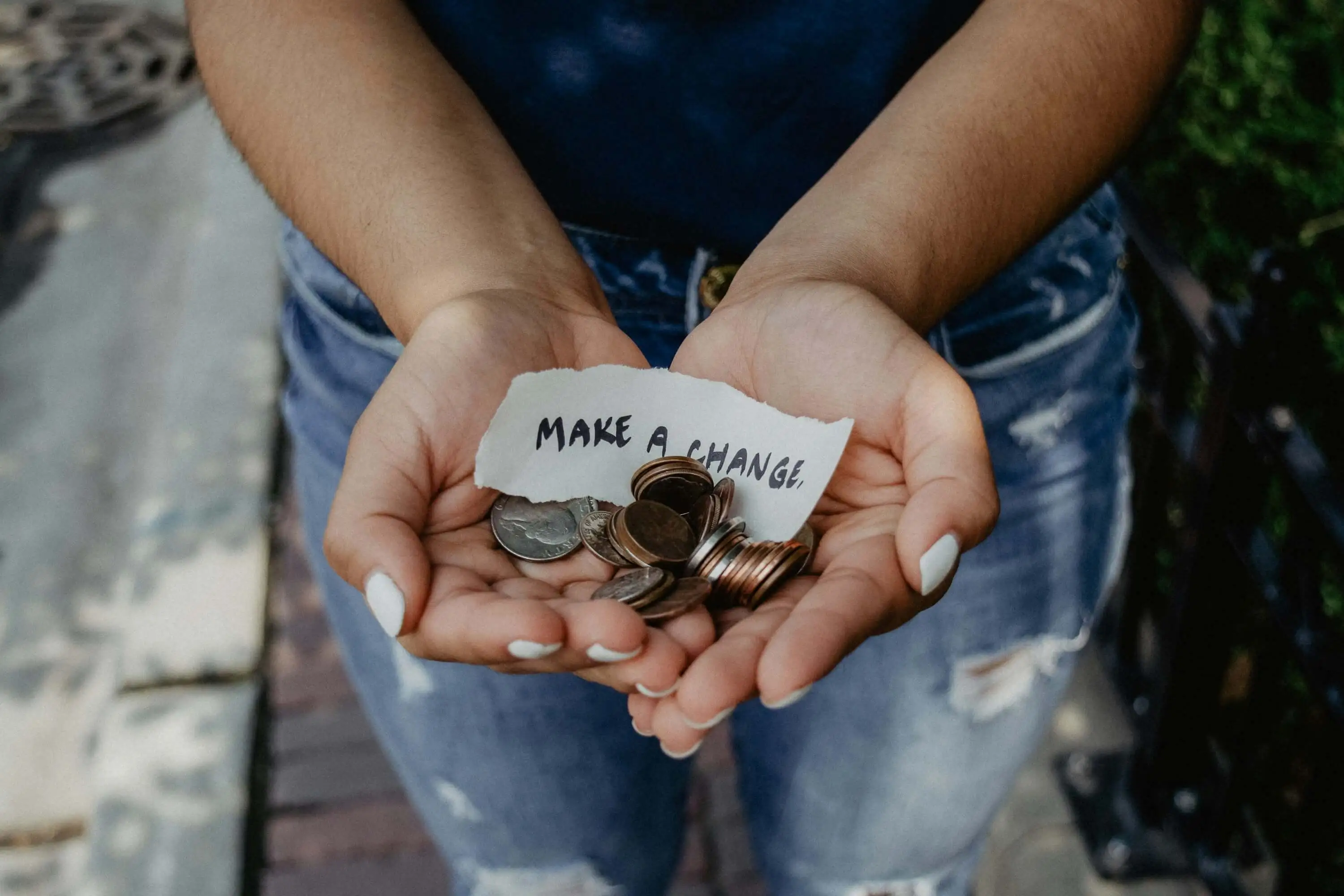 Hands with a small amount of change and a note that says make a change.